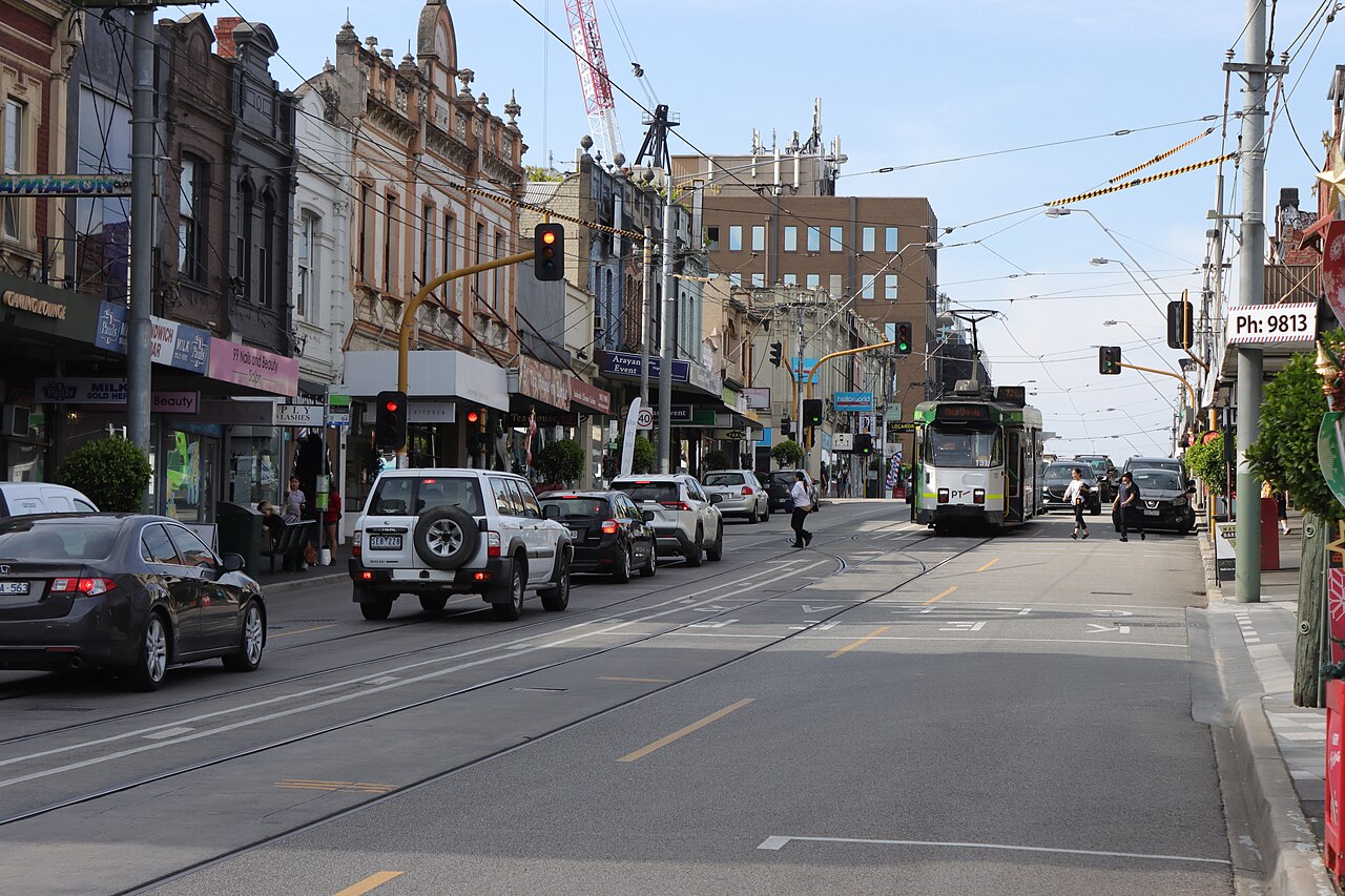 Burke Road near Cookson Street, with tram tracks and shops