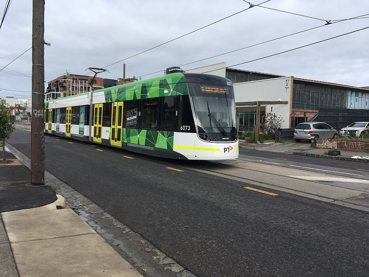 E-class tram passing along a wide street in East Brunswick