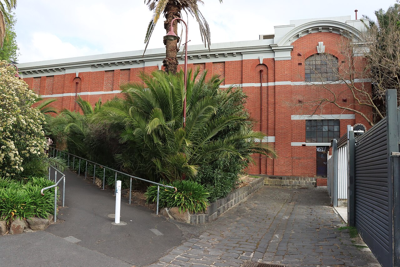 Red-brick exterior of Auburn Railway Station with garden