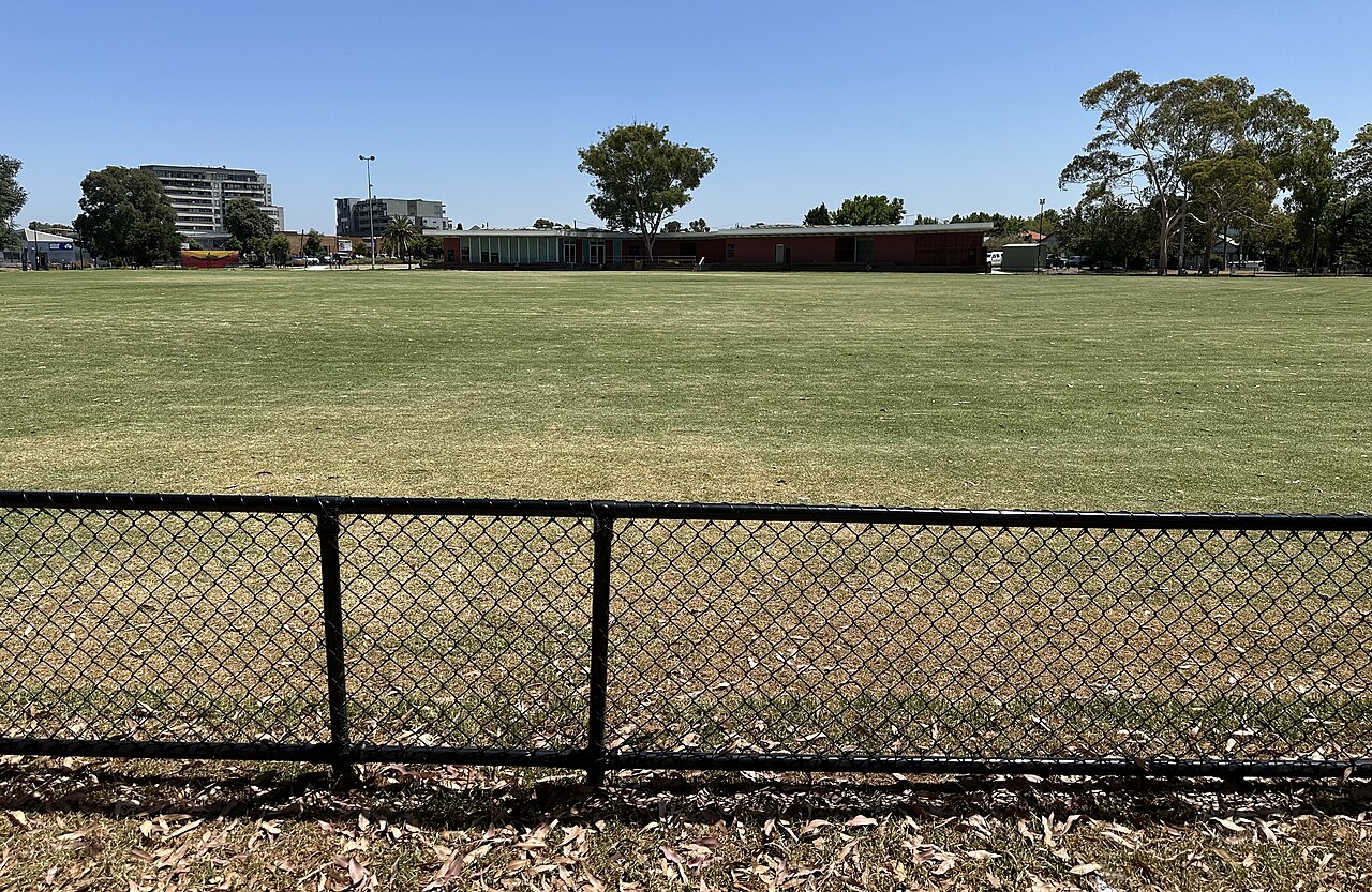 Open grassed oval behind a low fence at Fleming Park