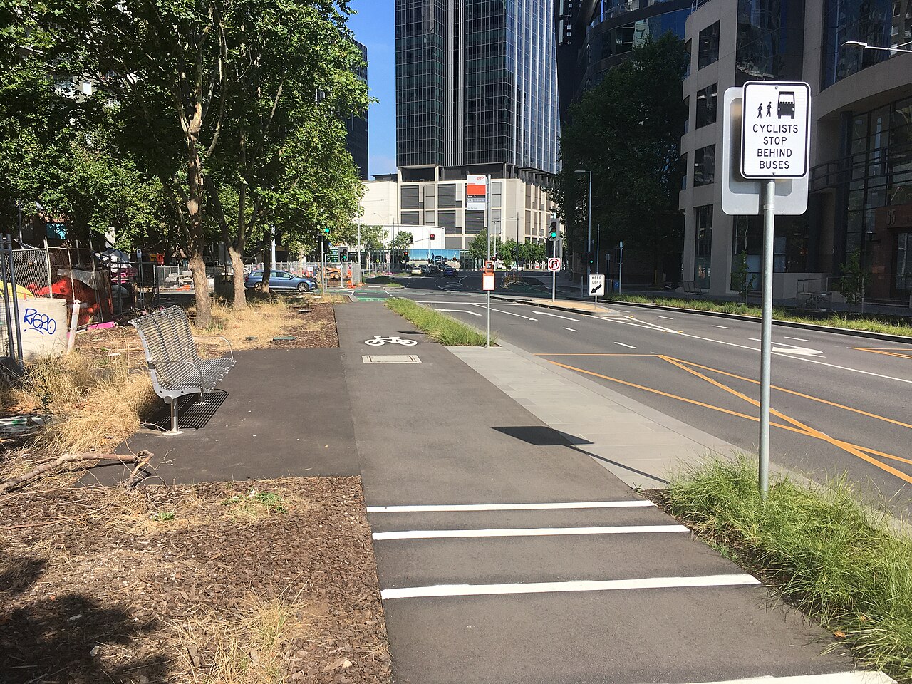 A 'floating' bus stop beside a bicycle lane on a tree-lined street