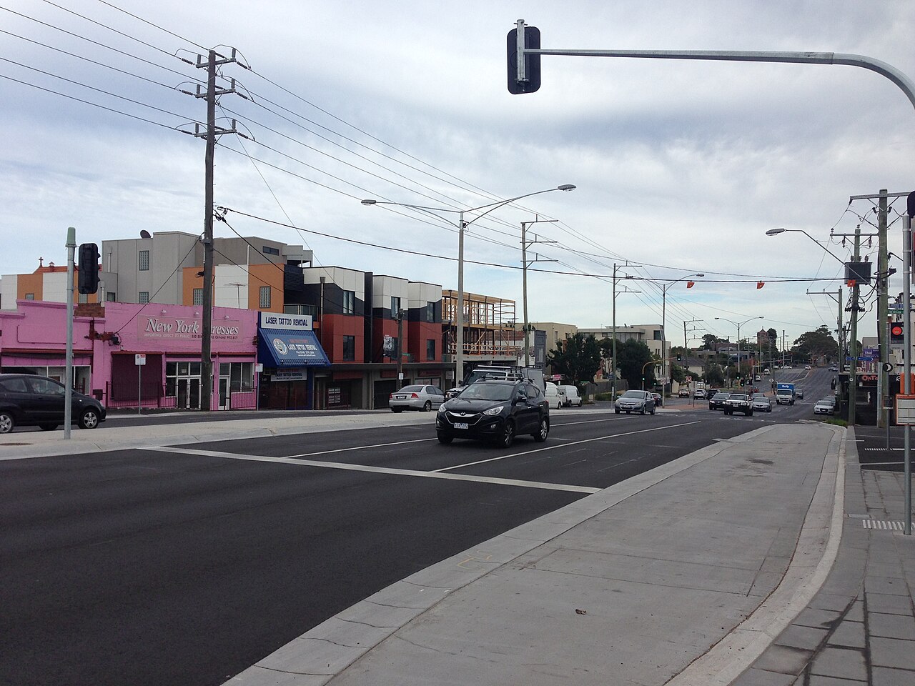 Road and shopfronts by the forecourt of Ormond railway station