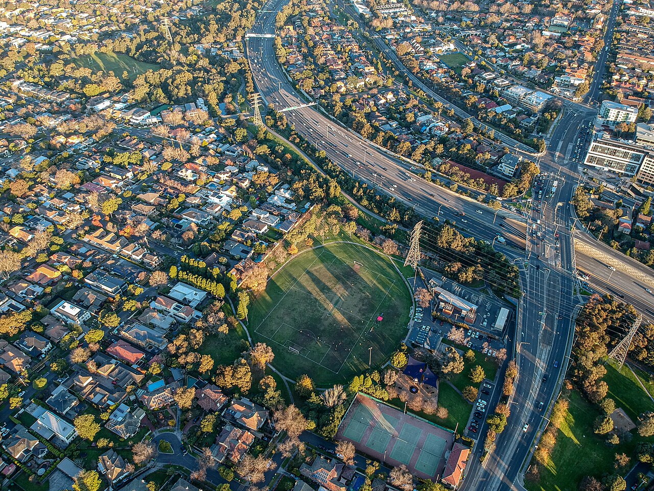 Aerial view of a freeway curving through leafy suburbs