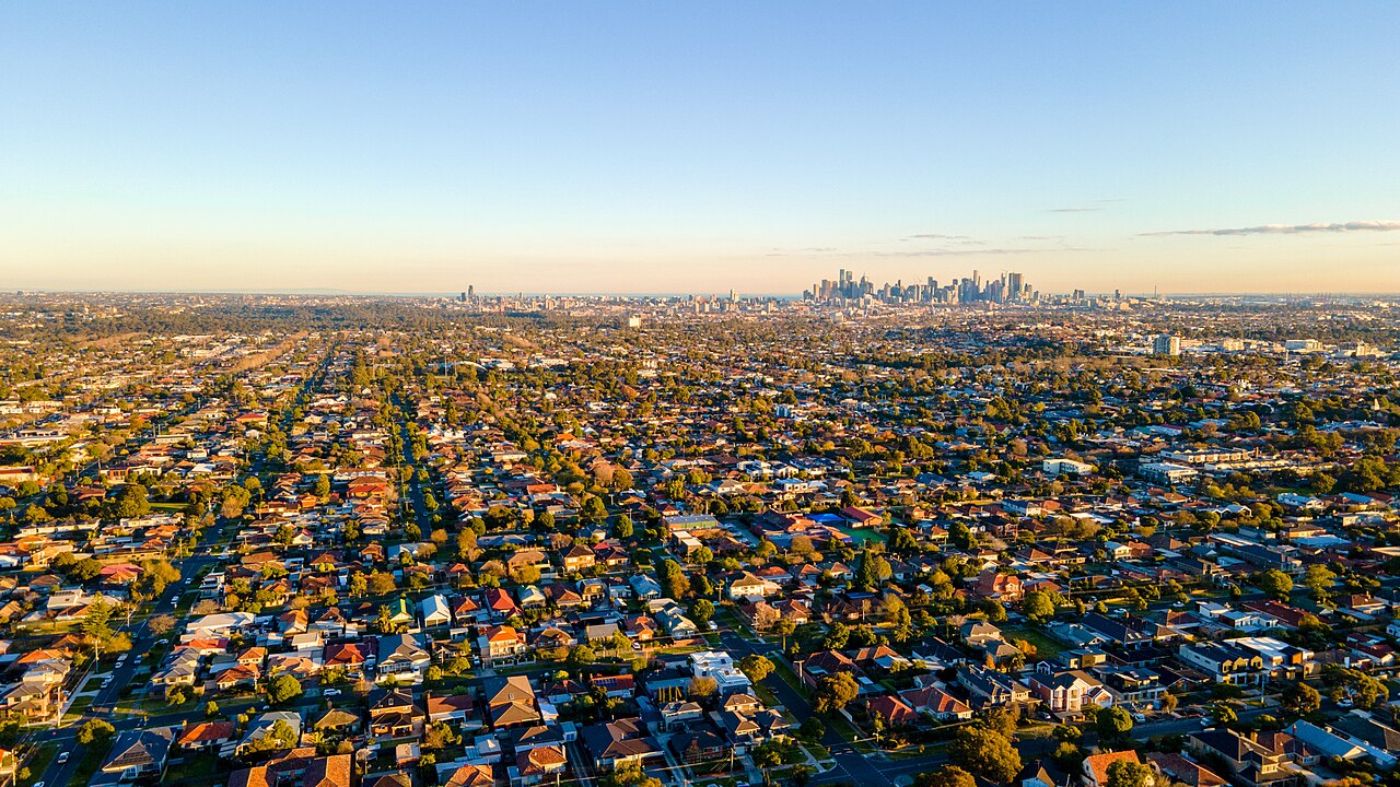 Melbourne city skyline seen from Hayes Park over autumn suburbs
