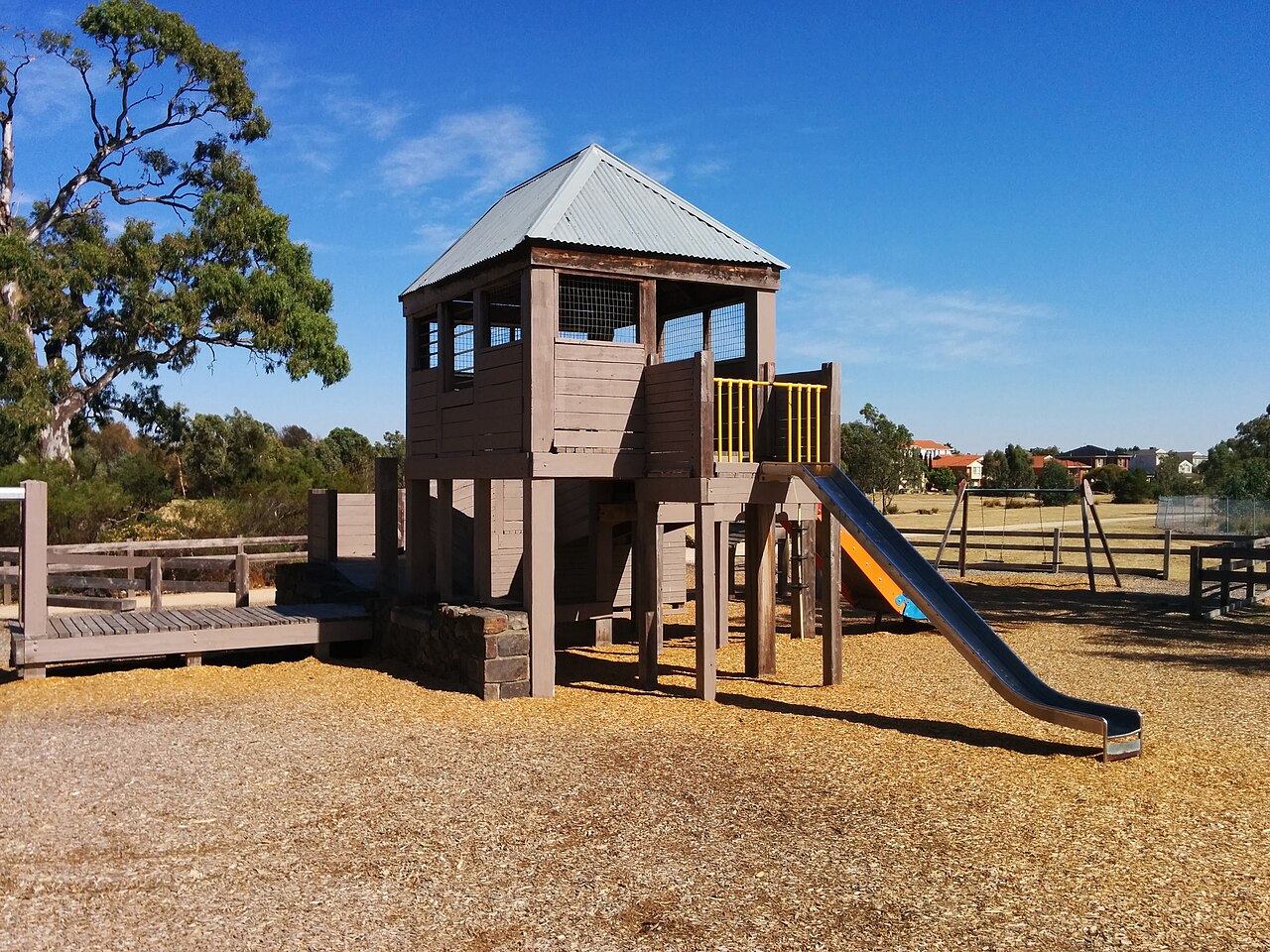 Timber playground tower and slide at Mill Park Stables Playground