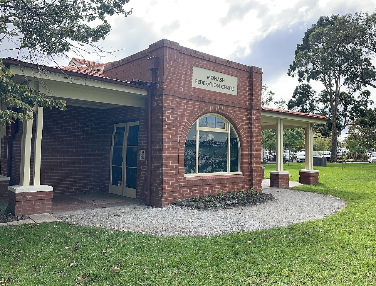 Red-brick Monash Federation Centre beside a lawn