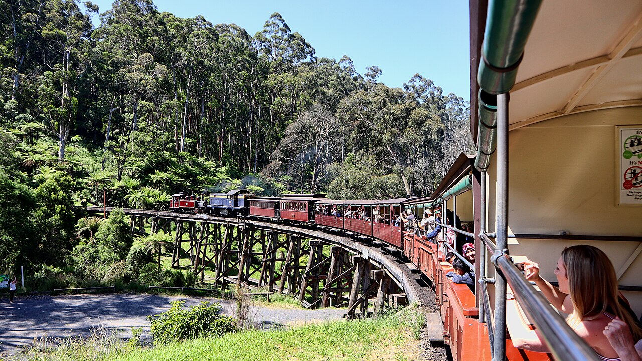 Narrow gauge steam train crossing a timber trestle bridge