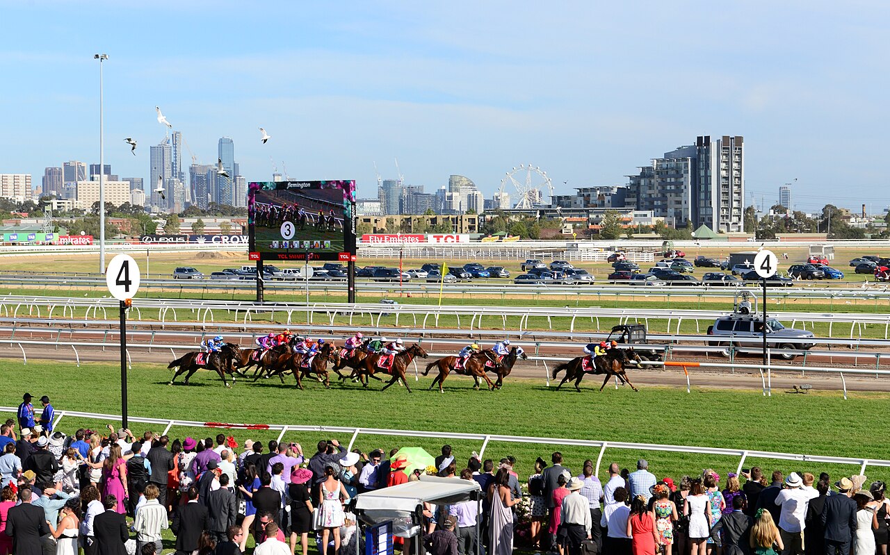 Horses racing at Flemington with the city skyline behind