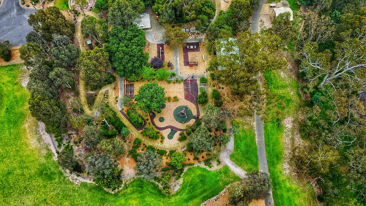 Top-down aerial view of a nature-themed playground among trees