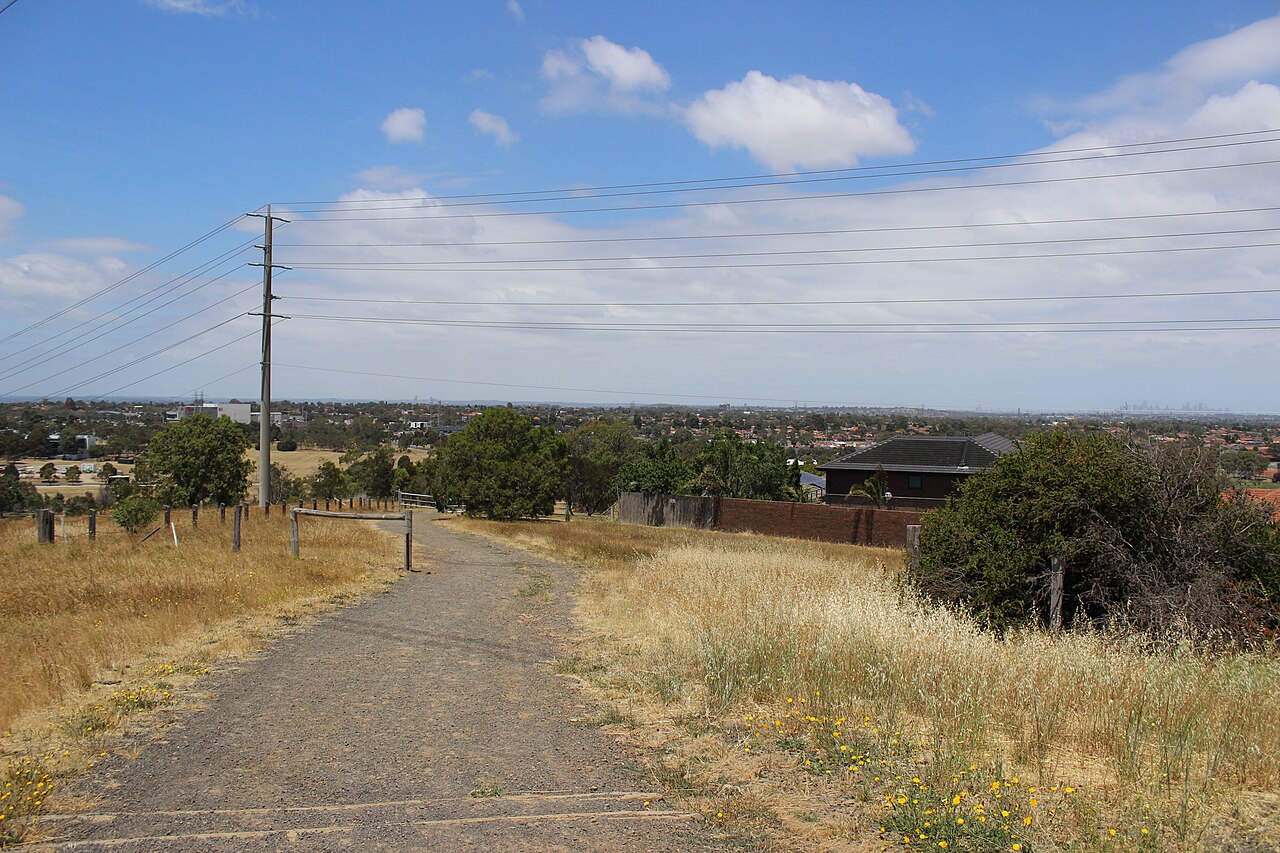 Path across grassland with a view of Epping and Mill Park