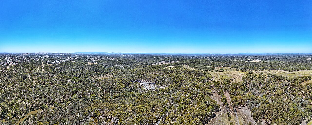 View across Plenty Gorge bushland towards the distant city skyline