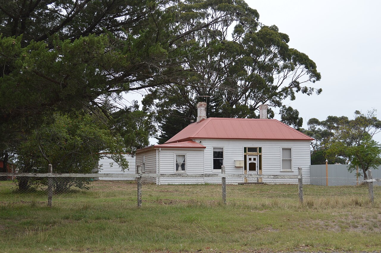 Old white farmhouse among trees at Wildwood