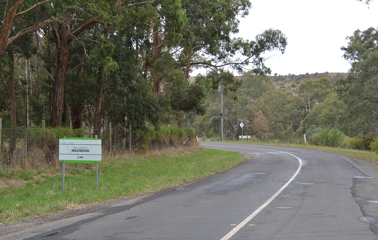 Winding rural road with the Wildwood town entry sign